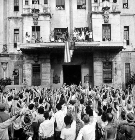 Santo Tomas Prison Liberation Carl Mydans. American flag draped over balcony of building as American and Filipino civilians cheer their release from the Japanese prison camp at Santo Tomas University folllowing Allied liberation of the city. Manila, Luzon, Philippines. February 05, 1945