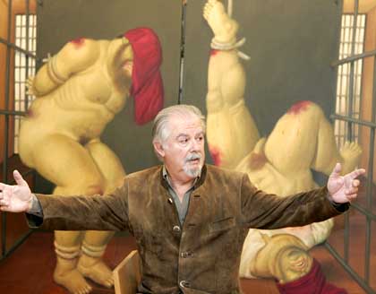 Colombian painter Fernando Botero gestures front of his new paintings depicting the horrors of U.S. guards' abuse of captives at Iraq's Abu Graib prison, Monday April 11, 2005 in Paris, France. Botero says he became so upset that he felt compelled to produce works showing his trademark chubby characters naked and being blooded by americans. (AP Photo/Francois Mori)