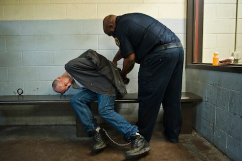 A Corrections Officer leads a prisoner who had tried to escape to a holding cell. The man was cut and bruised and claimed he had been beaten by officers after he tried to escape. © Peter Van Agtmael, 2011Dart_053 copy