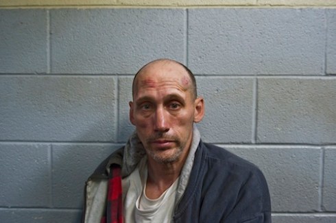 A Corrections Officer leads a prisoner who had tried to escape to a holding cell. The man was cut and bruised and claimed he had been beaten by officers after he tried to escape. © Peter Van Agtmael, 2011