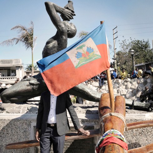 A pilgrim touches the Kita Nago, a tree trunk, which became a symbol of national unity, after a journey of two weeks across the country. Statue of the "Unknown Maroon" Champ de Mars, City of Port-au-Prince