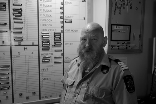 In front of the white board, with the location of every inmate