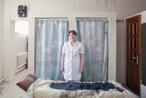 Woman with her mud. 2012 Sanatorium worker prepares to remove the rest of used healing mud. The mud reserves are coming to the end as a source mud lake is now placed on the territory of Kashagan oil refinery plant. Atyrau, Kazakhstan. 2012